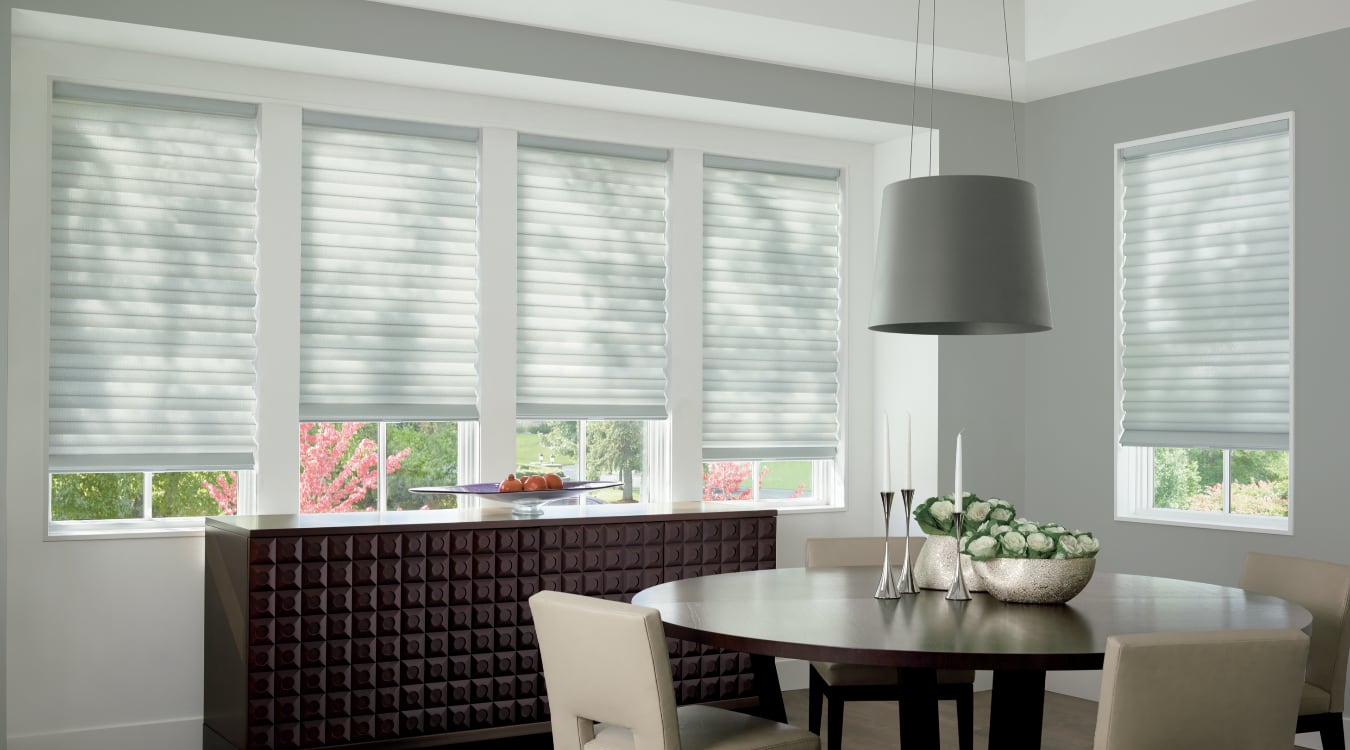 Custom cordless roller shades have a clean look and are appropriate for any room. Cordless motorized shades in a New York dining room